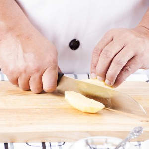 Chef Cutting Potato On Wooden Broad