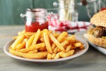 Tasty sandwiches and french fries on plate, on wooden background