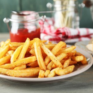 Tasty sandwiches and french fries on plate, on wooden background