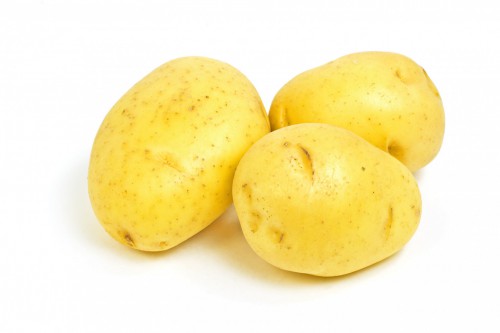 Raw Yukon Gold potatoes on white background horizontal format